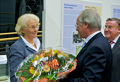 Hety Meerpohl, die Ehefrau des Preisträgers, freut sich über einen großen Blumenstrauß.